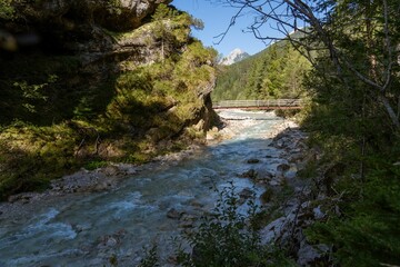 Obraz premium Picturesque wooden bridge spanning over a babbling mountain stream in Gais Valley, Leutasch, Tyrol