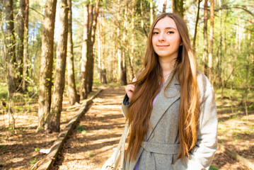 Portrait of a beautiful teenage girl, young woman with long hair in the park	