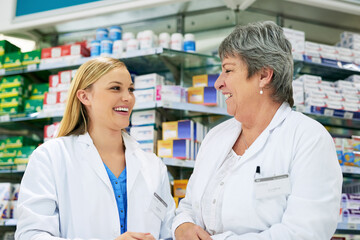 Woman, colleagues and pharmacy store for healthcare teamwork or laughing, medication or purchase. Female people, humor and chemist internship for tablet consulting or professional, shopping or shelf