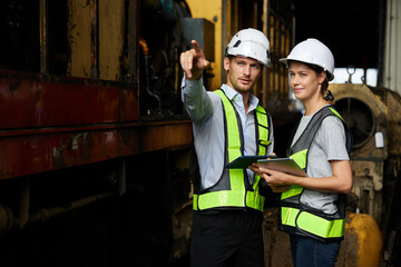 engineers or workers checking and pointing to something at construction train station