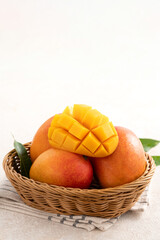 Fresh slice cut juicy mango on gray table background with leaf.