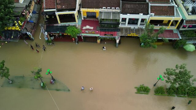 Aerial footage of people walking in water-flooded streets of Hoi An town after the floods, Vietnam