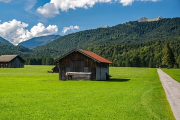 Obraz premium Scenic Alpine landscape with a green field and rural houses. Upper Bavaria, Germany