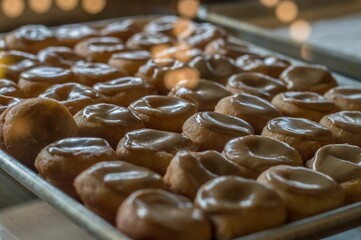 Baking pan filled with freshly-baked donuts, each covered in a sweet glaze