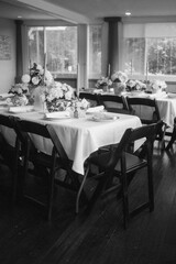 Elegantly set table adorned with flowers and candles, creating a warm atmosphere in grayscale