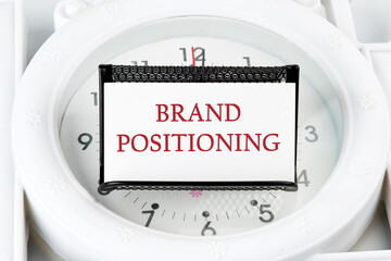 Brand positioning is shown on a business card on a stand on a lying watch