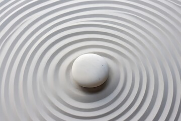 Naklejka premium Zen rock garden with circular white sand patterns viewed from above for a peaceful ambiance