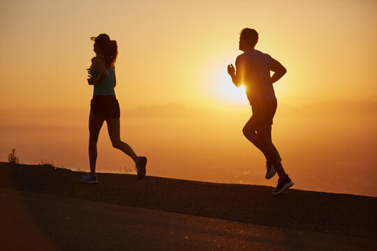 Sunrise, couple and running silhouette outdoor for race training, exercise and fitness with cardio for health. Wellness, sport and athlete with runner partner in nature in the morning with sprint