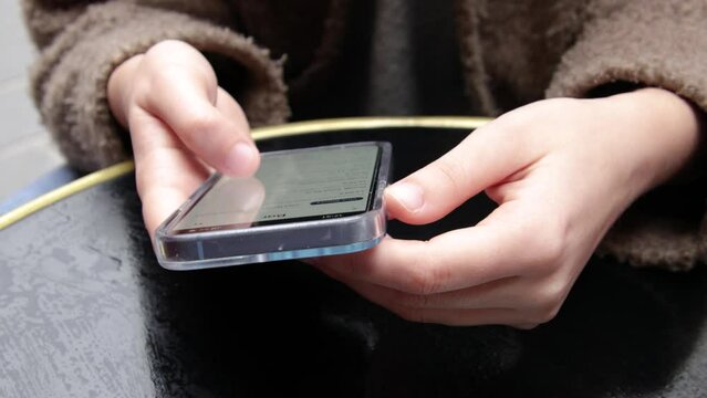 gros plan sur la main d'une femme consultant son smartphone