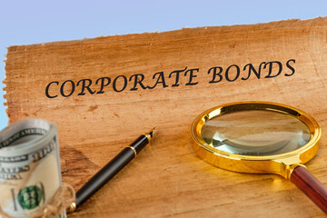 Finance and economics concept. CORPORATE BONDS written on papyrus next to a magnifying glass and money