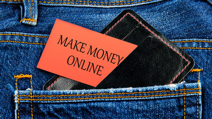 Business concept. MAKE MONEY ONLINE lettering written on business cards from a purse from a jeans...
