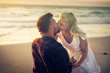 Kiss, engagement and couple with ring on beach for proposal, celebration and anniversary outdoors....