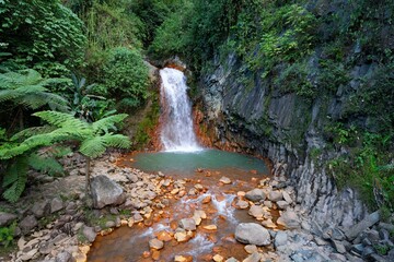 Red Rocks waterfall cascading over a rugged landscape of rocks in Negros Oriental, Philippines