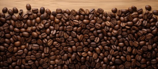 Fototapeta premium Close up coffee beans and and lined paper on wooden table top view. copy space available