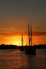 Vertical of boats sailing at golden sunset