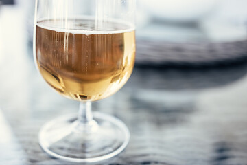 The bottom of a half-drunk glass of beer on a glass table