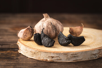 Black fermented garlic is a gourmet ingredient in cuisine for pasta, sauce and soups. rustic style,...