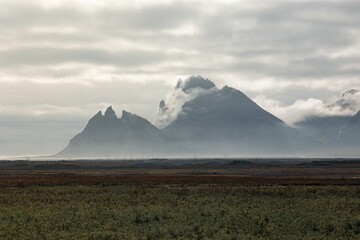 Majestic mountain peak is hidden in fog and clouds. Iceland