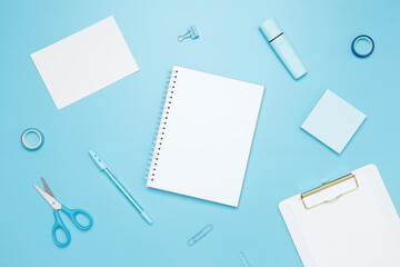 Creative flat lay mockup design of workspace. Top view composition with white notebook, to do list and stationery on blue background