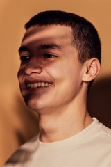 Obraz premium Close-up portrait of a male thoughtful teenager in warm indoor light