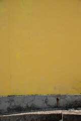 黄色く塗られた古いコンクリートの壁