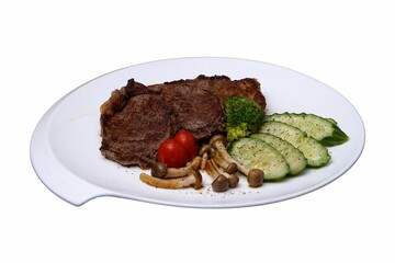 Juicy steak served on a white plate with freshly cooked vegetables and ripe tomatoes on the side