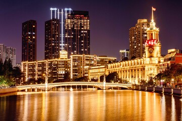 Fototapeta premium cityscape of a bustling metropolitan area illuminated by bright lights in the night sky, Shanghai