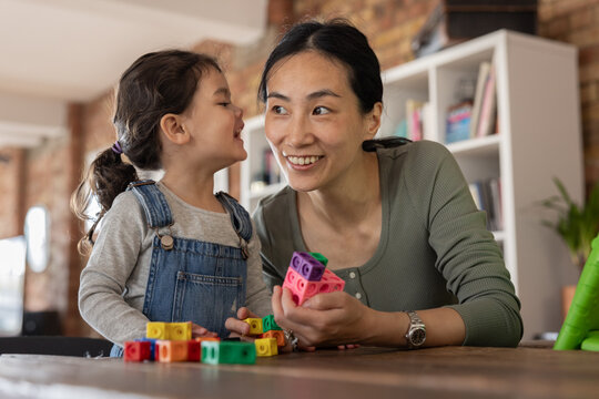Asian mother helping daughter to learn counting and maths 