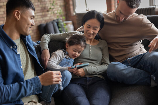 Extended Asian family looking at photos on a smartphone