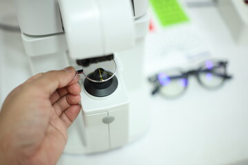 close up of a hand holding a lenses glasses 