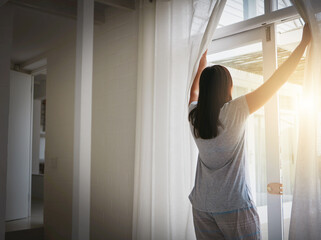 Back, woman and open curtain in morning, window and fresh wake up with sunrise in hotel ready for...