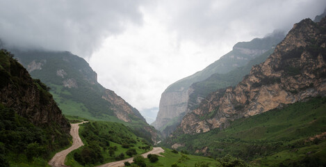 Cloudy and rainy day in spring, low storm clouds.Summer mountain landscape. Amazing view of the valley and lush green pastures in the Georgia. Valley surrounded by high mountain ranges.