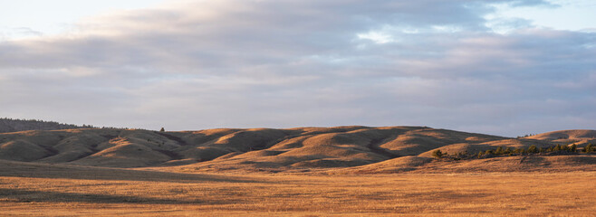 Sunrise on an empty valley amazing hilly landscape. Colorful grassy and hilly natural landscape in...
