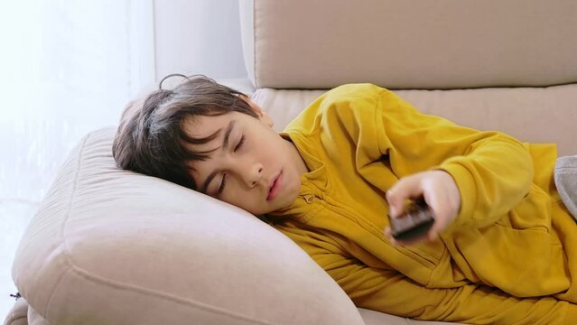 Young bored boy watching tv