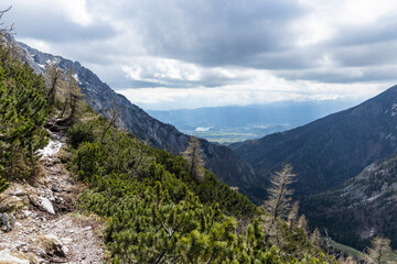 Begunjščica panorama of mountain trekking to the highest peak. View of the Alps, climbing with via ferrata. Distant view of Lake Bled from above. Sports holidays, life of adventure in the countryside