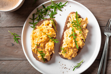 Scrambled eggs sandwiches with arugula microgreens