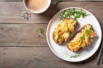 Scrambled eggs sandwiches with arugula microgreens