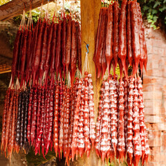 Bright churchkhela hangs in clusters in the food market close-up, soft selective focus. Traditional...