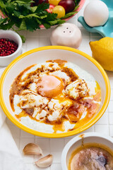 Cilbir or Turkish Eggs in white bowl. . Traditional Turkish breakfast, Turkish cuisine concept.