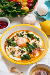 Cilbir or Turkish Eggs in white bowl. Turkish cuisine concept.