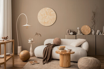 Interior design of cozy living room with wooden wall panel, stylish sofa, round coffee table, braided pouf, brown sideboard, vase with branch, beige lamp and personal accessories. Home decor. Template