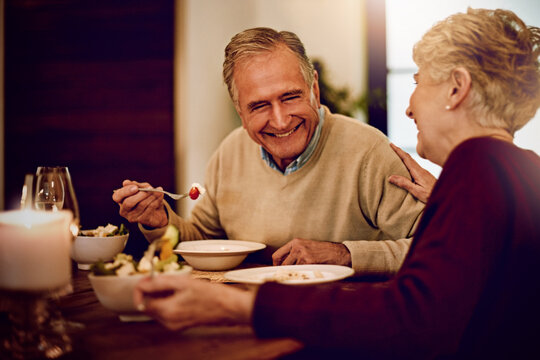 Senior, couple and dinner on date with love on anniversary in retirement with happy marriage. Elderly people, laughing and eating together in fine dining restaurant with food, care and relationship