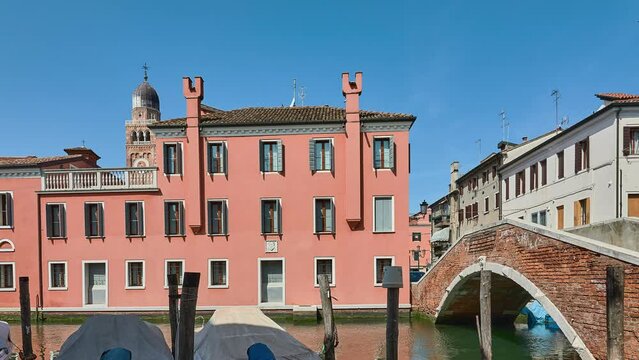 CHIOGGIA, ITALY - APRIL 19 2018: brick bridge Zitelle Vecchie over the Vena canal. Old buildings near the canal.