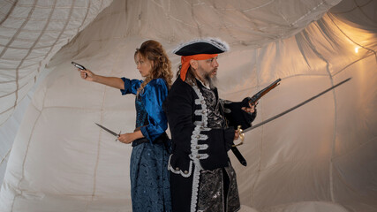 A lady with a dagger and a pirate in an old doublet with a saber