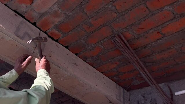 Wooden slab is getting tightened through screw and steel binding wire for constructing building column