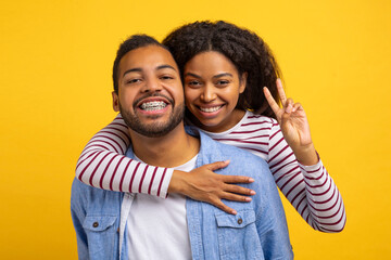 African American man and woman are embracing each other tightly, with big smiles on their faces....