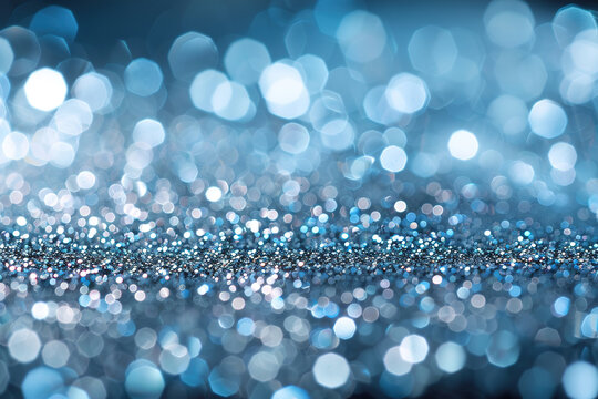 A vibrant mix of blue and silver bokeh creating a dazzling and illuminated background, scattered with blurred light orbs and sparkles