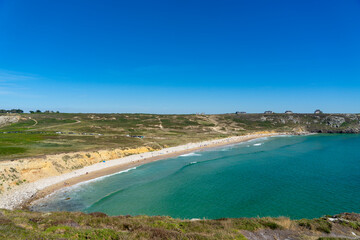 L'anse de Pen Hat se dévoile sous un ciel bleu, avec les eaux turquoises de la mer d'Iroise et le sable doré, offrant une vision paradisiaque de la côte bretonne.
