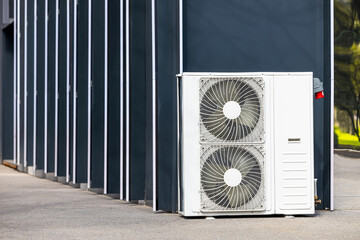 The outdoor unit of an industrial air conditioner stands on the ground