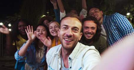 POV of handsome Caucasian man speaking on video outdoor. Beautiful happy African American and Asian...